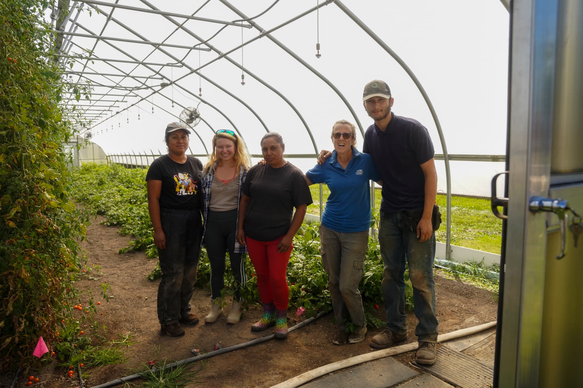 The farming team standing together in the greenhouse