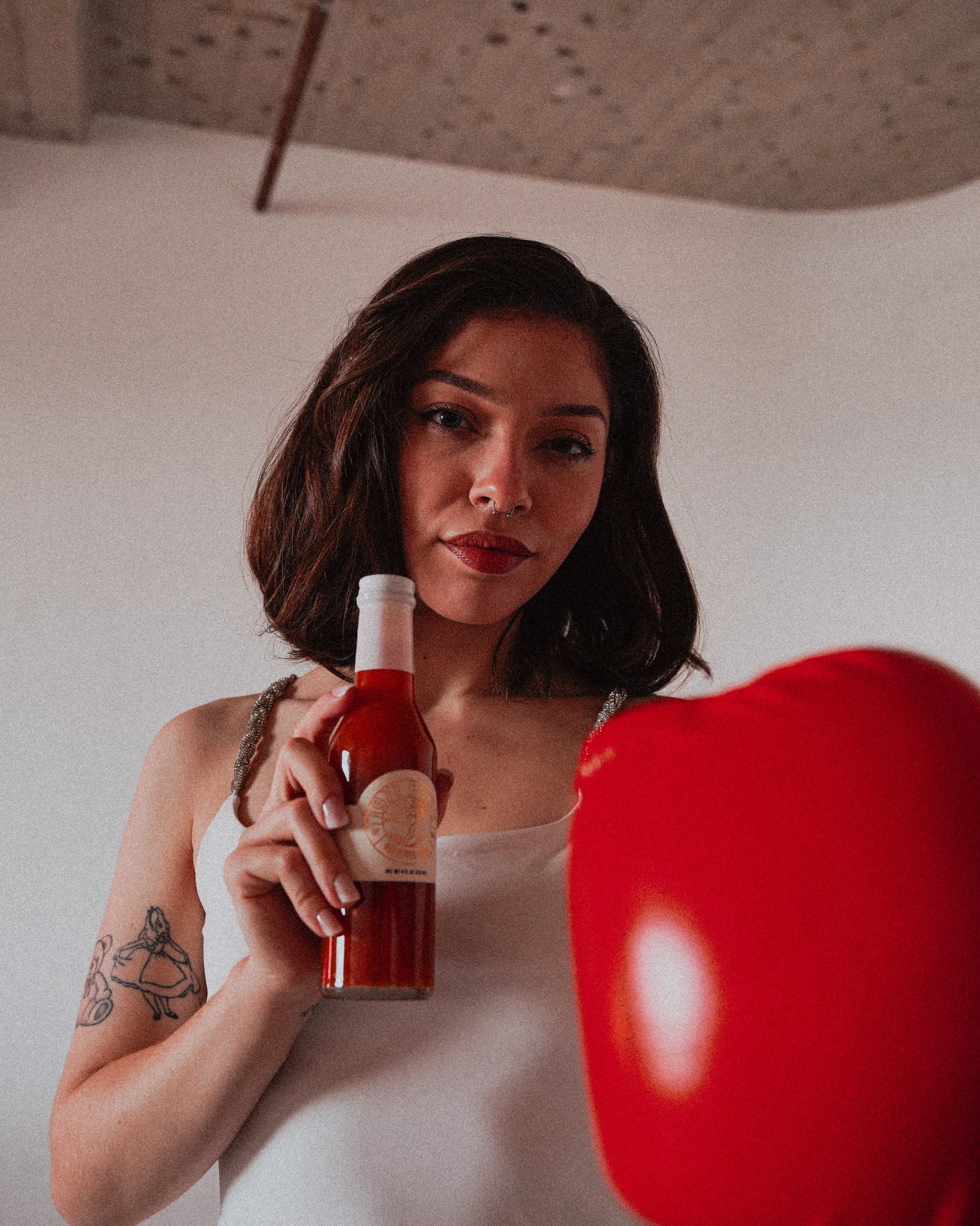 Close portrait, bottle held beside the boxing glove
