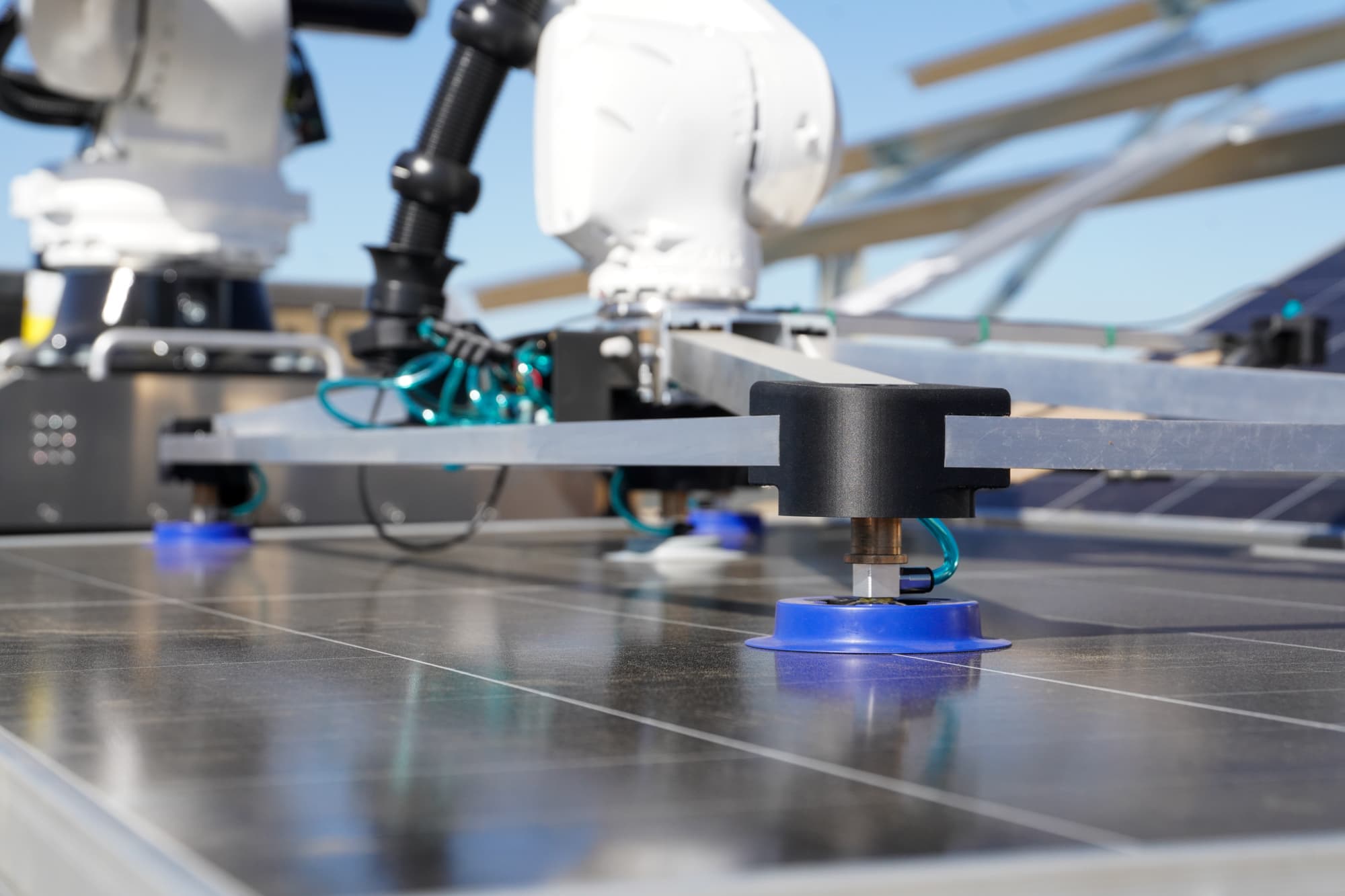 Vacuum gripper lowering onto a solar panel at the Arvin site