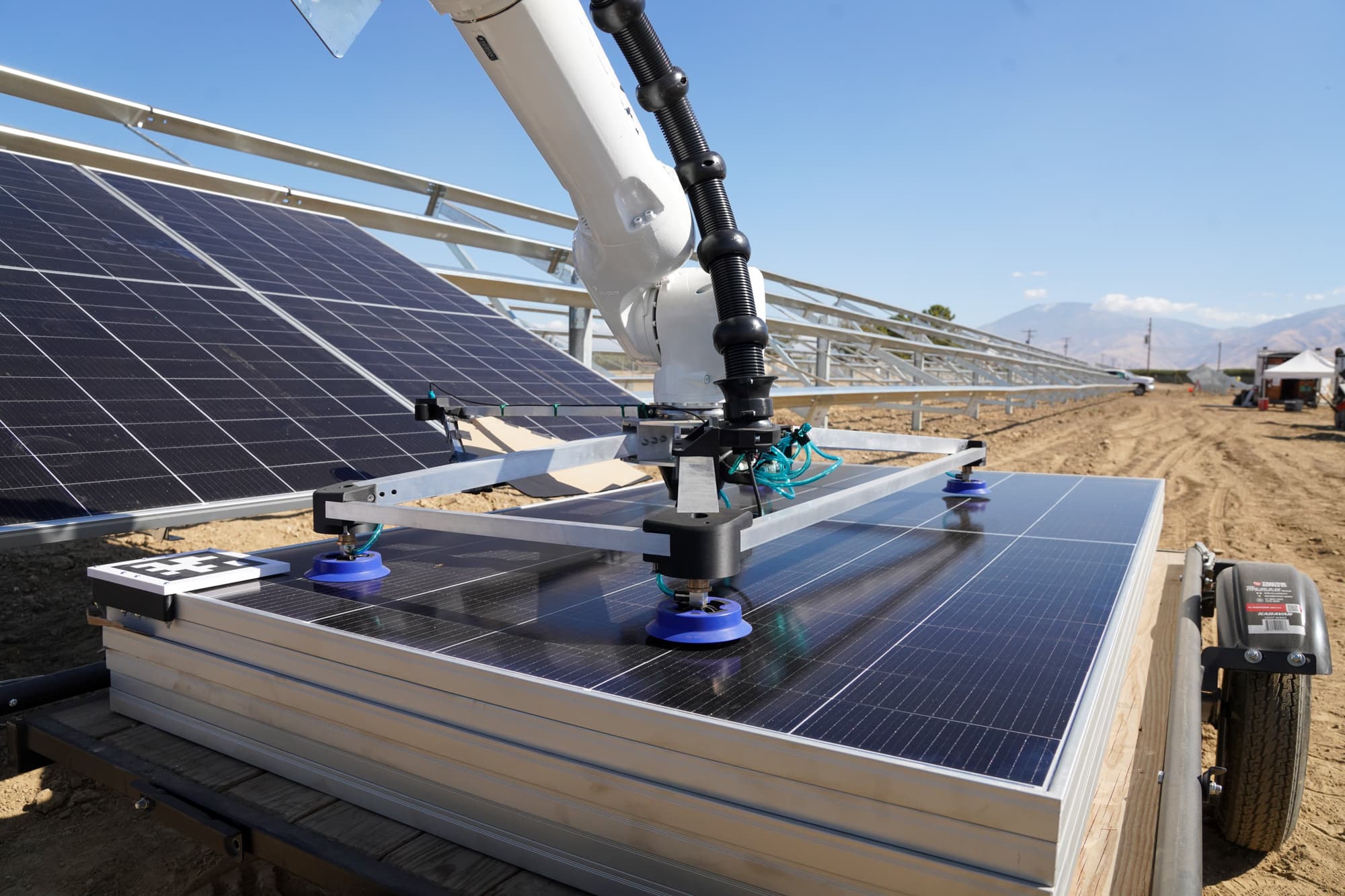 Robotic arm holding a panel over the rack with the Central Valley behind