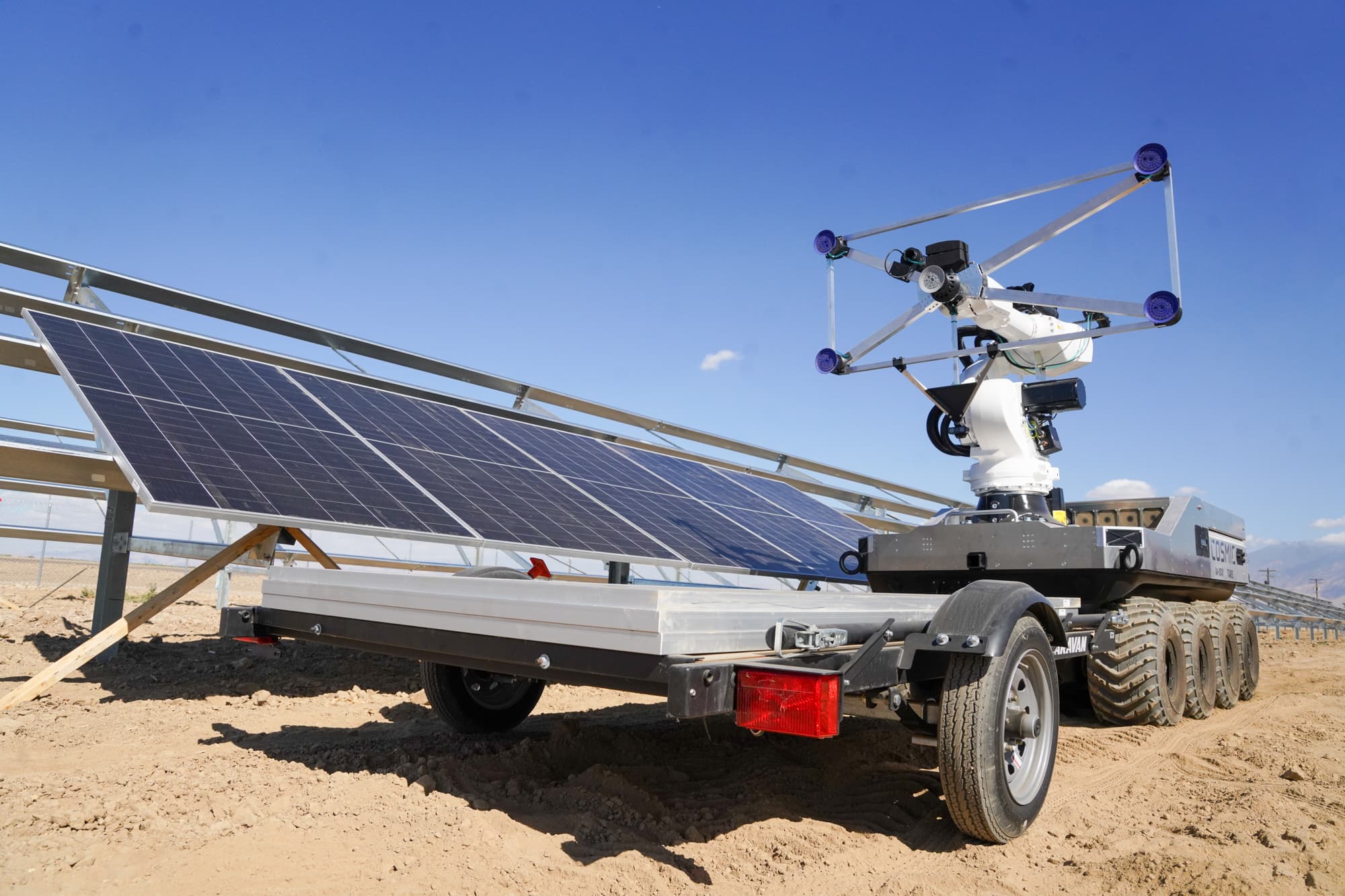 Cosmic Robotics prototype on its tracked platform beside a solar rack, Arvin, California