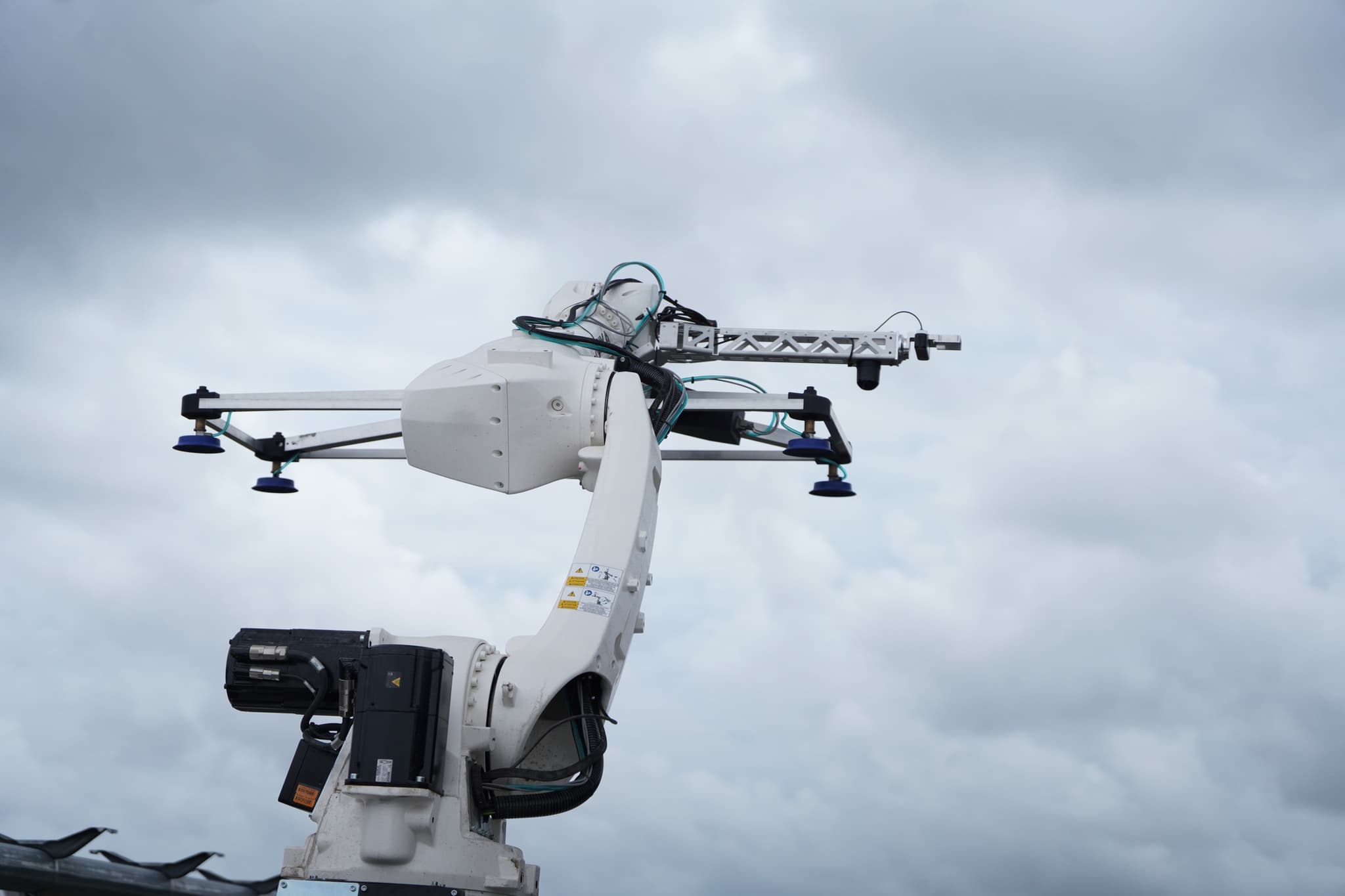 KUKA arm and vacuum gripper raised against the sky