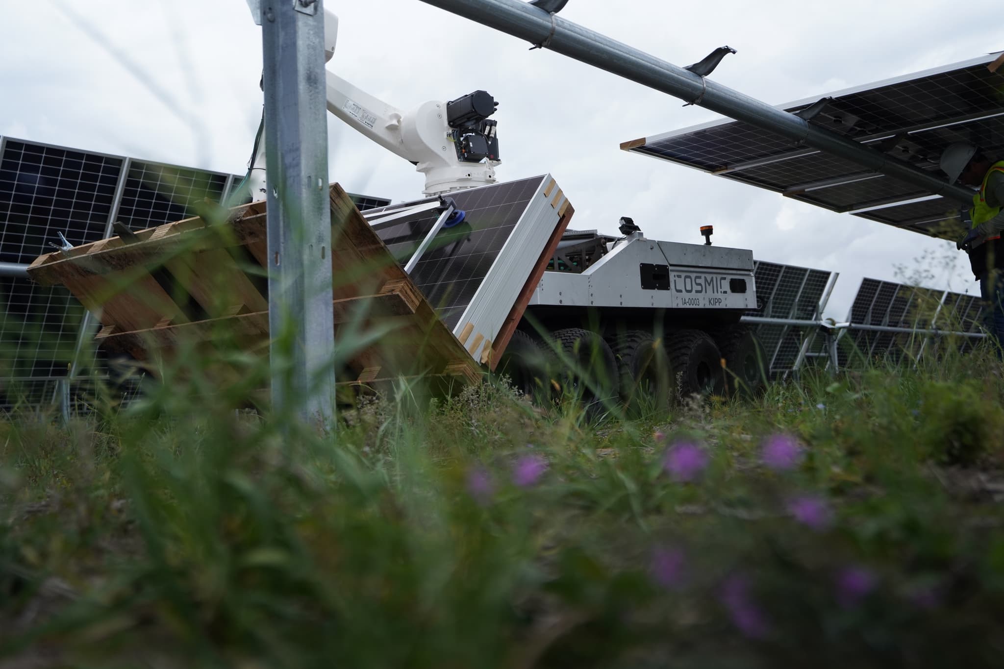 Low angle through grass of the robot placing a panel