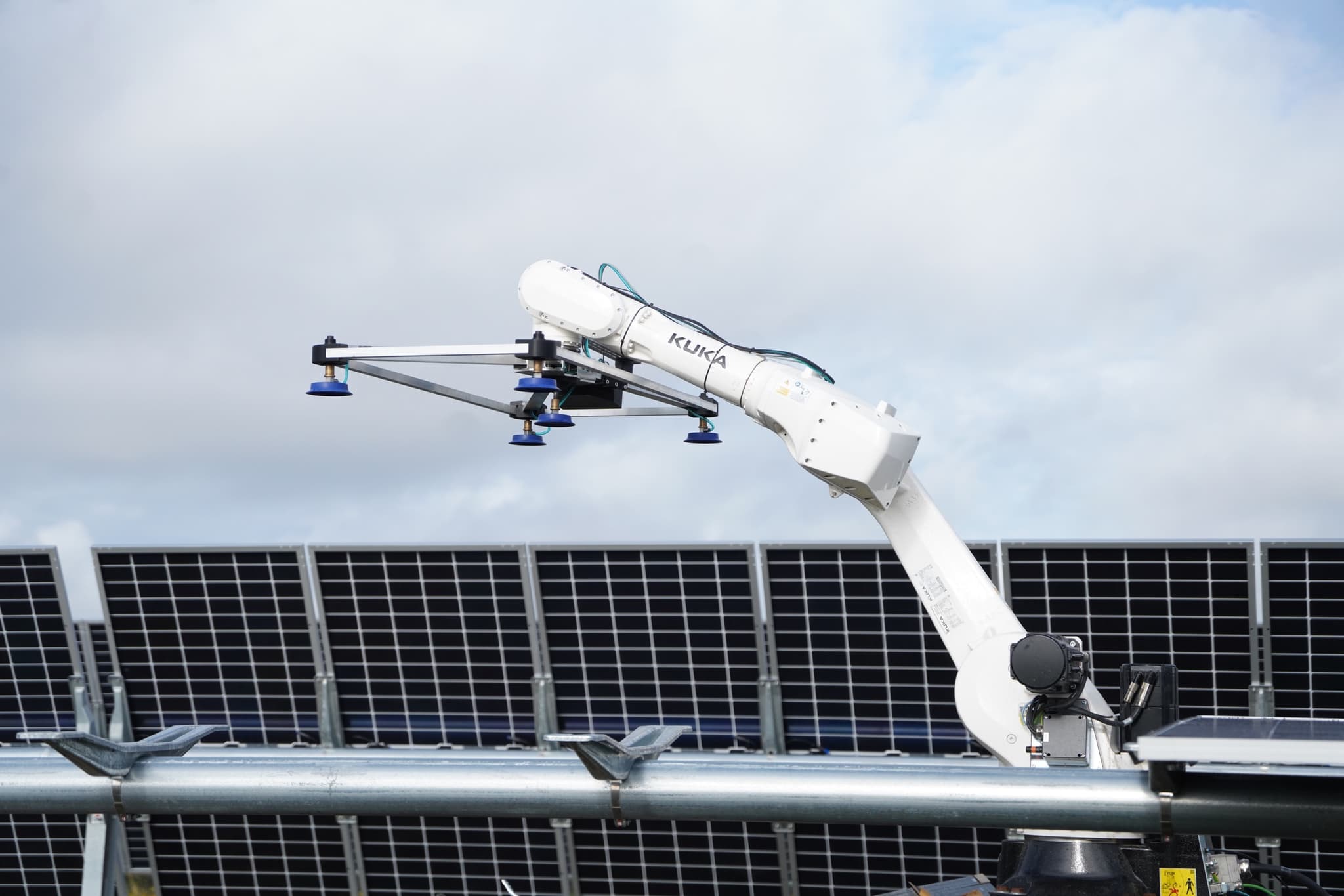 Robotic arm reaching over a racking row