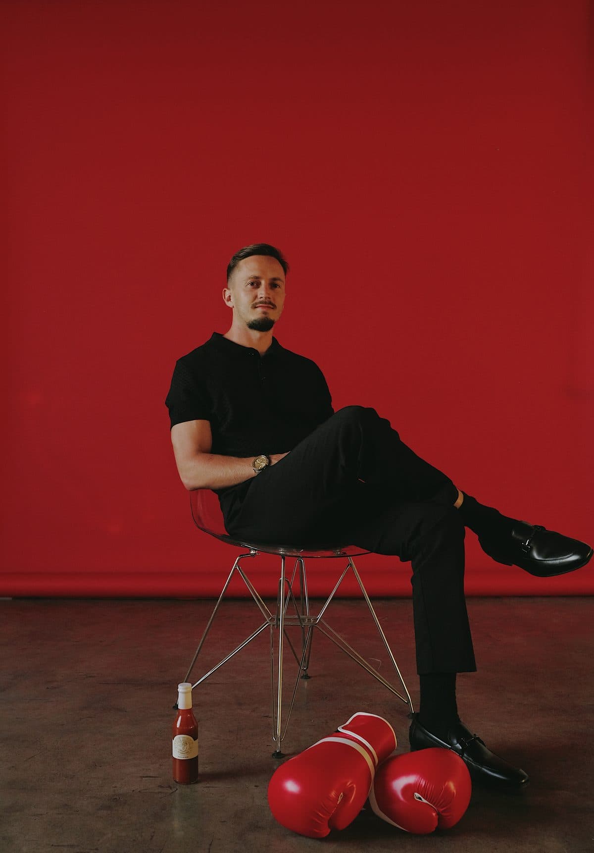 Sebastian Werz seated on a red backdrop with a bottle of 1971 Hook and a pair of boxing gloves at his feet