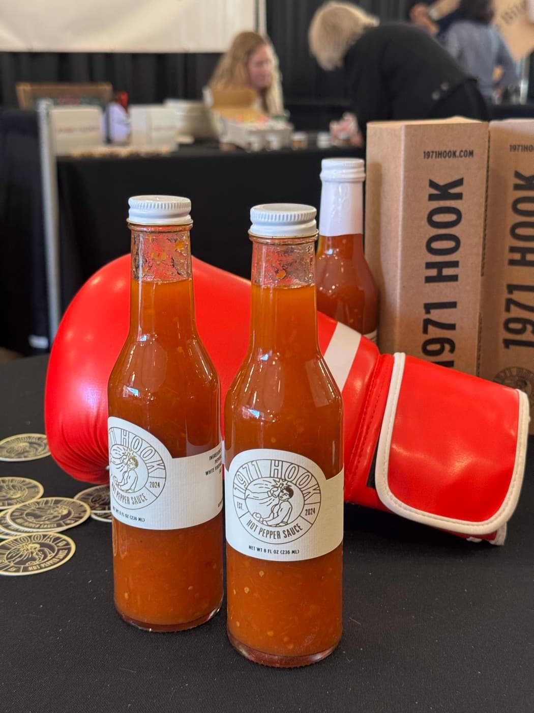 1971 Hook bottles and a red boxing glove on the table at an MMA event