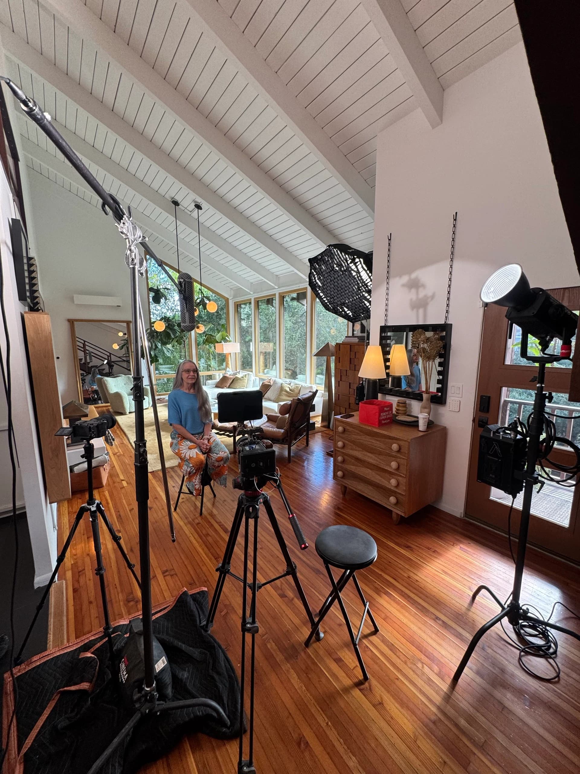 Donna seated for an interview between two cameras with overhead sound and lighting